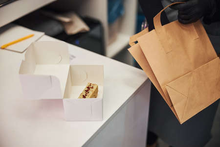 Responsible cafe staff preparing packages for delivery