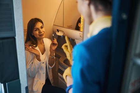 Young female passenger apologizing for smoking in the aircraft
