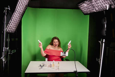 Excited woman with facial cream in each handの写真素材