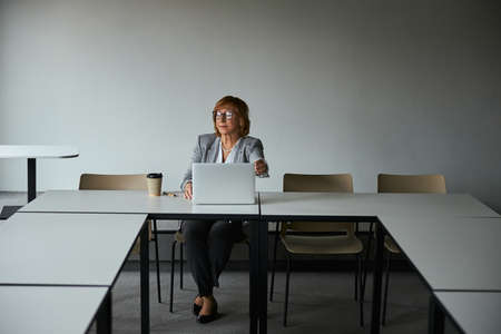 Thoughtful senior businesswoman preparing for online meeting
