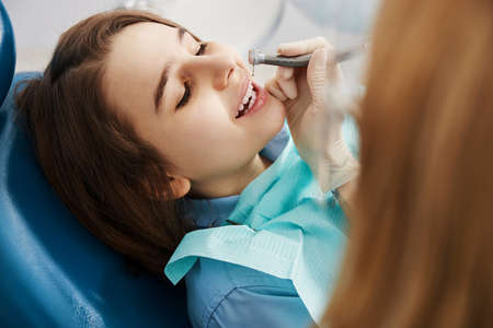 Eager child lying under dental drill during operation