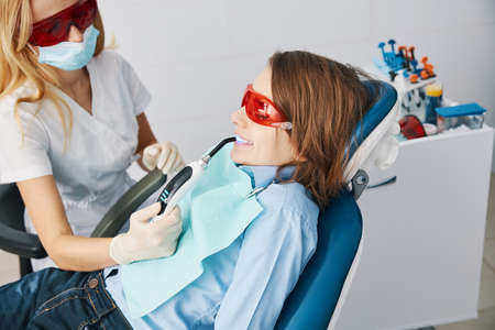 Doctor and patient in safety glasses during curing lights treatmentの写真素材