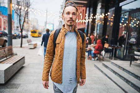 Calm young man walking alone in the city