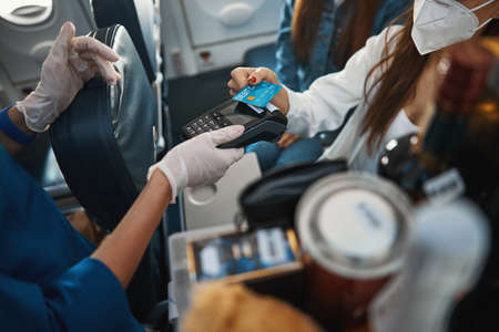 Woman paying for purchase with credit card on a plane