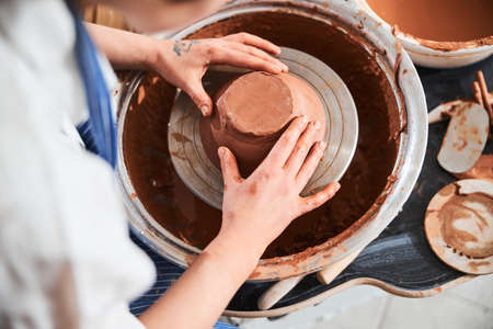Pottery artist forming a bowl from clay with hands