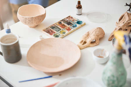 Ceramic plates and paint palette standing on tableの写真素材