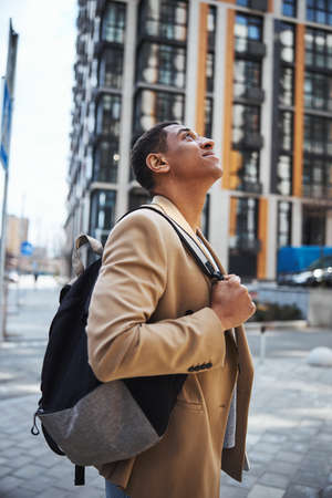 Close up of dreamy man looking at modern building