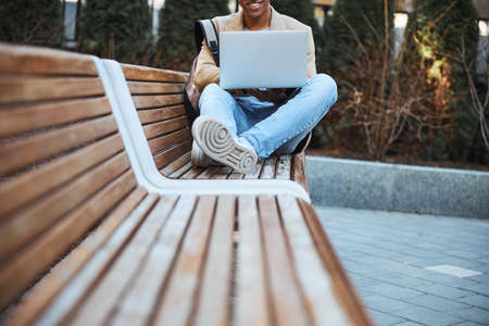 Focused photo on cheerful man staring at his laptopの写真素材