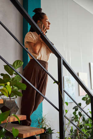 Calm beautiful florist calling on the smartphoneの写真素材