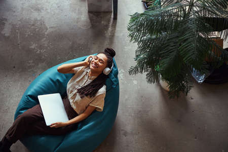 Merry woman listening to music in wireless headphonesの写真素材