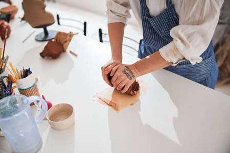 Focused photo on female hands warming clay
