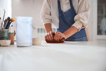 Competent potter preparing clay for doing crockeryの写真素材