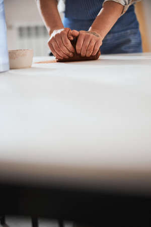 Focused photo on female hands warming clay