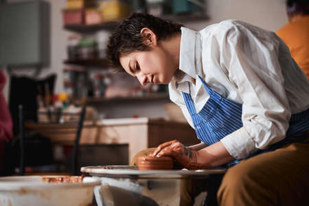 Close up of serious master working with raw ceramic