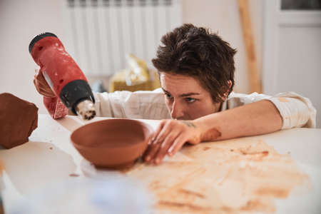 Close up of serious ceramist demonstrating her workの写真素材