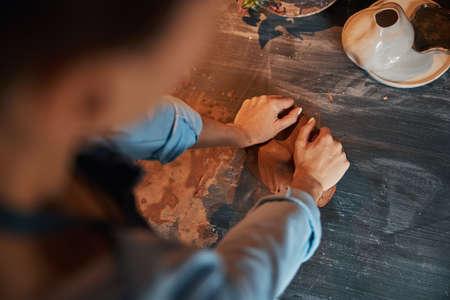 Unrecognized woman arms at the modeling process in pottery workshopの写真素材