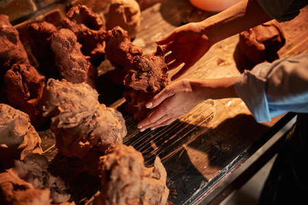 Unrecognized female ceramicist modeling something in art cozy workshopの写真素材