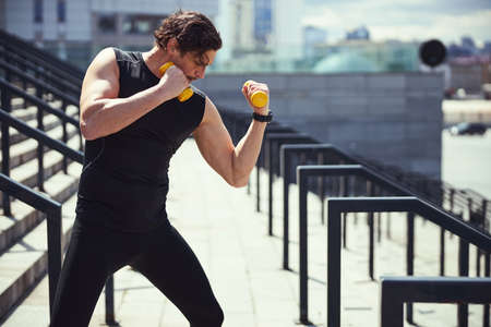 Kind brunette sportsman demonstrating his strength in handsの写真素材