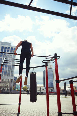 Silhouette of sportsman keeping balance on bar