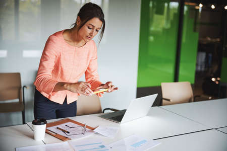 Young attractive business lady working with documents and laptop in the modern bright open space...