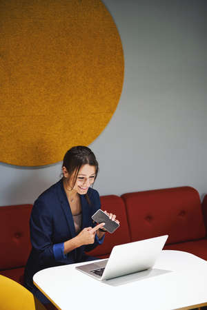 Beautiful elegant Caucasian female social manager talking with business partner on video call in...