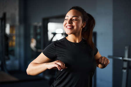 Jolly young woman doing fitness in gym