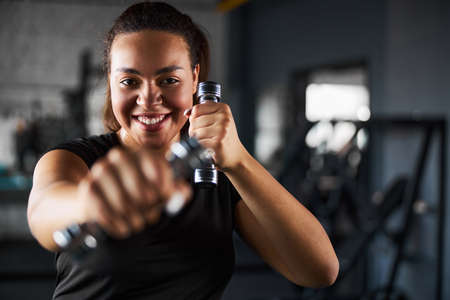 Happy woman doing tae bo workout indoors