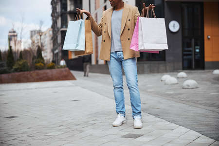 Focused photo on international man holding paper bags