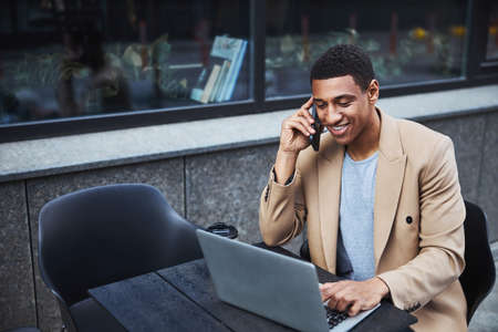 Positive delighted male person talking per telephone