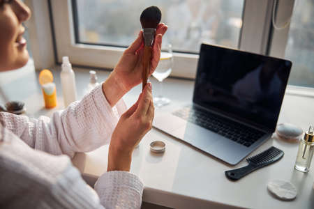 Cheerful female person looking at natural brushの写真素材