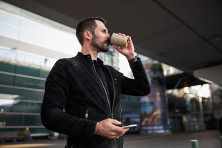 Taking sip of hot beverage outdoors in the city