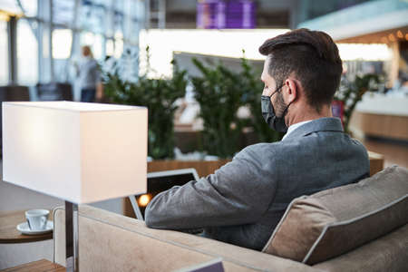 Dark haired man in suit sitting in the hall aloneの写真素材