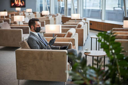 Business lounge zone with one visitor in itの写真素材