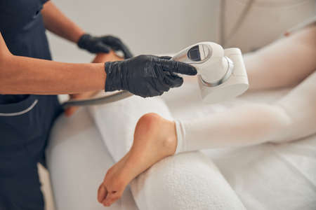 Process of using special device for reducing fat on legsの写真素材