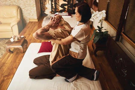 Mature man during rehabilitation in oriental studioの写真素材