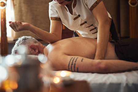 Grizzled male during traditional thai massage for backの写真素材
