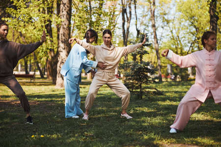 Tai chi instructor correcting stance of female studentの写真素材