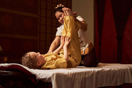 Girl lying with legs raised up on coachの写真素材