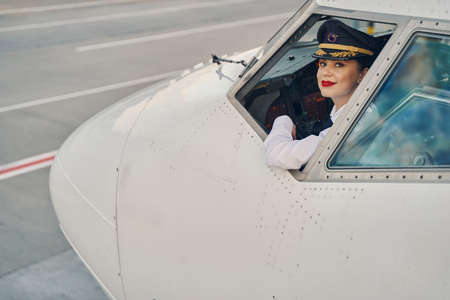 Woman aviator posing for the camera in the flight deckの写真素材