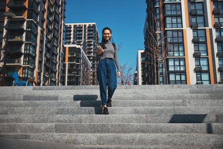 Pleased female traveler going down the stairsの写真素材