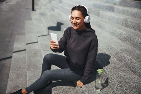 Happy good-looking woman listening to music on her smartphone