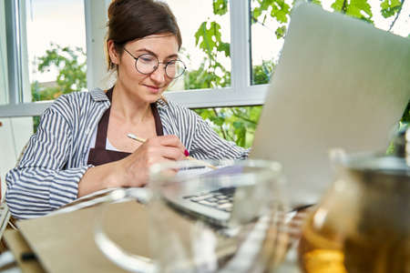 Woman filling out working documents at home