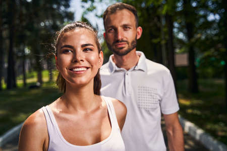 Joyous pleased attractive woman and her boyfriend standing outside