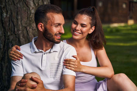 Couple in love sitting by a tree outside