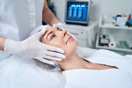 Positive delighted woman lying on couch during procedure
