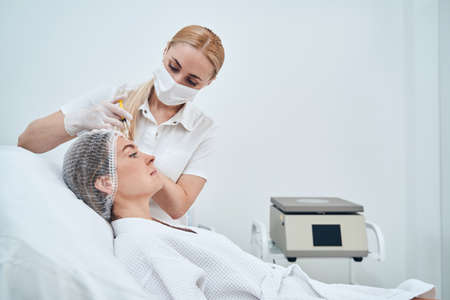 Competent young medical worker doing mesotherapy treatmentの写真素材