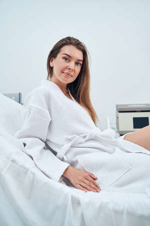Positive delighted female patient sitting on couchの写真素材