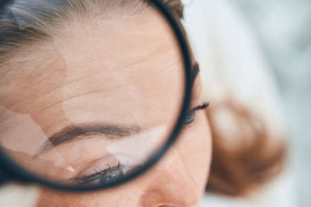 Competent medical worker checking quality of facial skinの写真素材