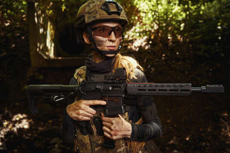 Female person in protective glasses holding gunの写真素材