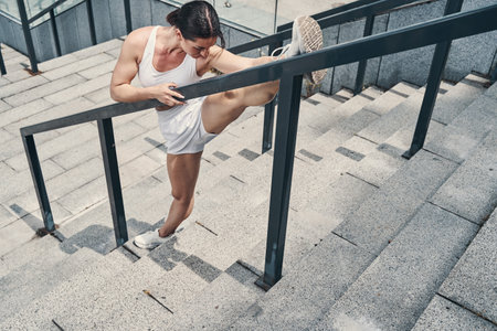 Athletic female doing physical activities on stairs outdoorsの写真素材